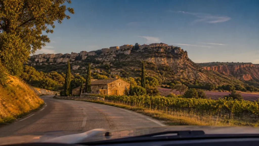 Villages perchés luberon : route sinueuse et villages sur crête, coucher du soleil