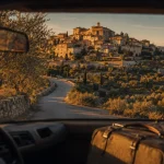 Route des villages perchés luberon : route vers Gordes, oliviers et village perché à l’heure dorée
